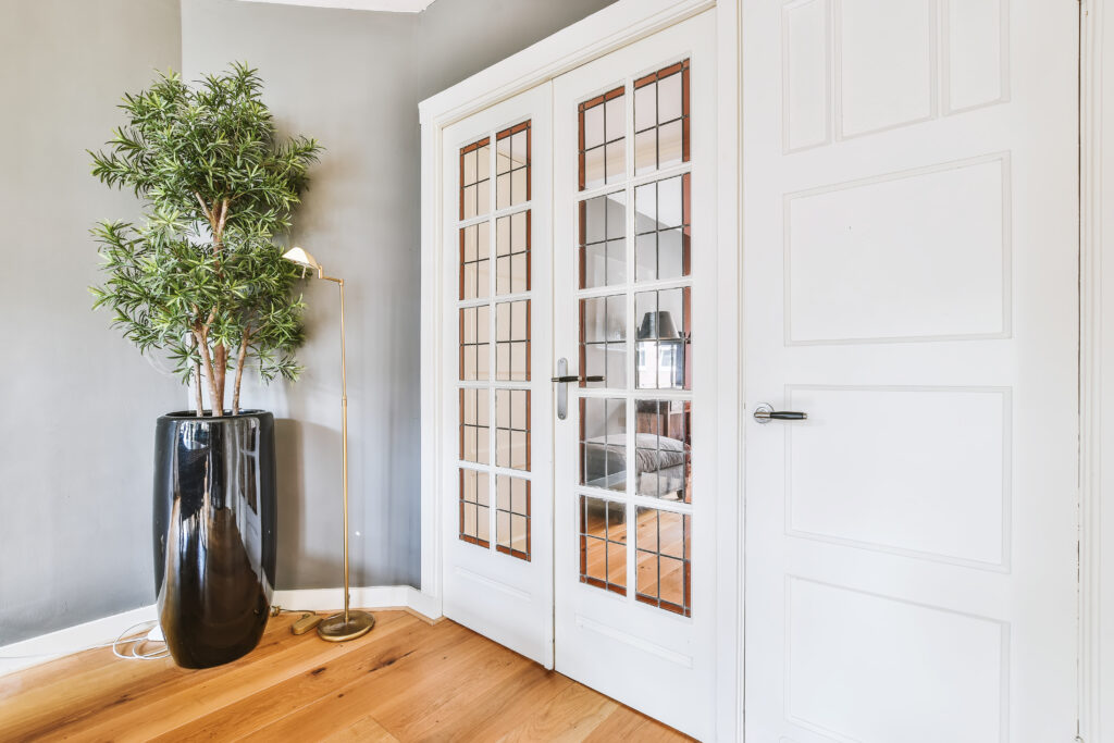 White casement doors lead to a cozy living space with warm lighting.