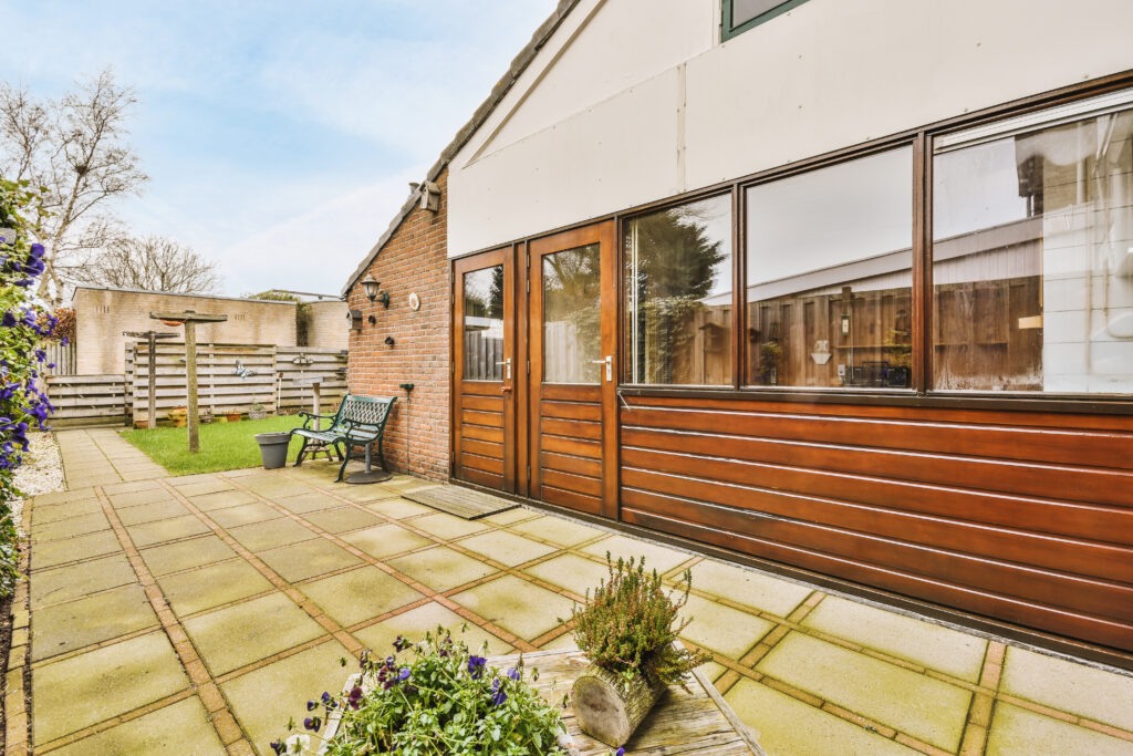 Casement doors open to a neat patio, giving easy access between the house and yard.