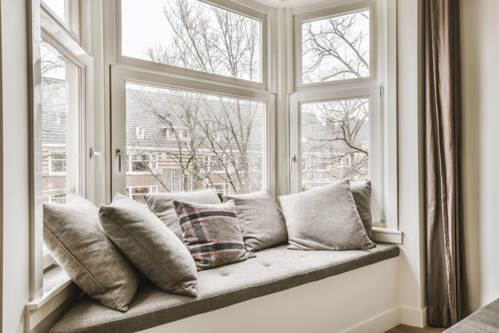 Stunning soft window sill near a large window with pillows