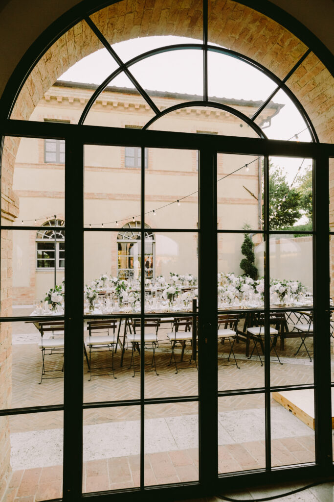 Glass doors open to an elegant courtyard set for a special gathering or event.